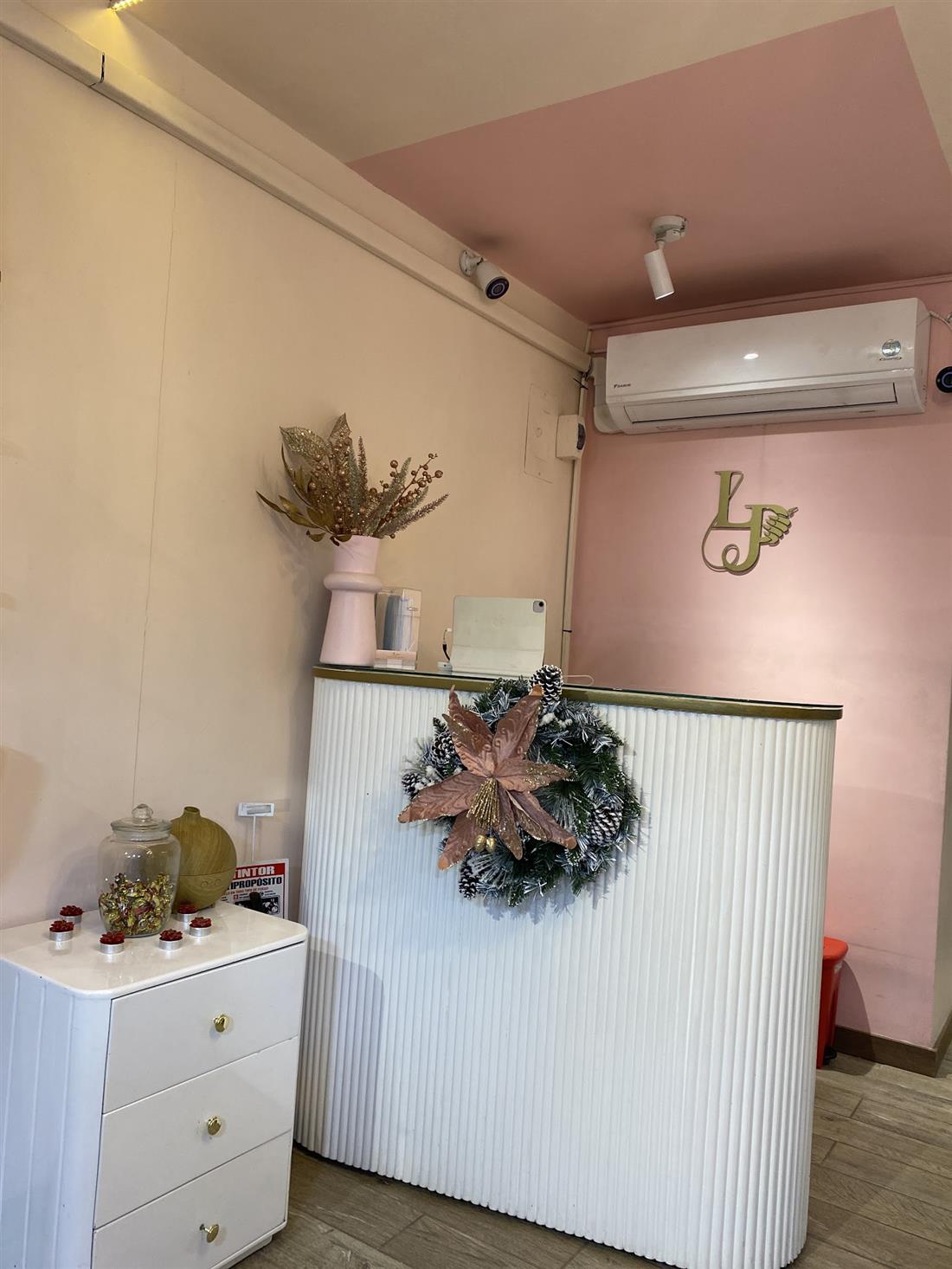 Recepción de La Pezuñería con el monograma LP en la pared rosada
