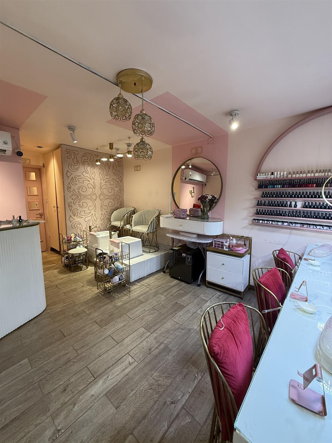 Salón de La Pezuñería con mesas de manicura y sillas rosadas
