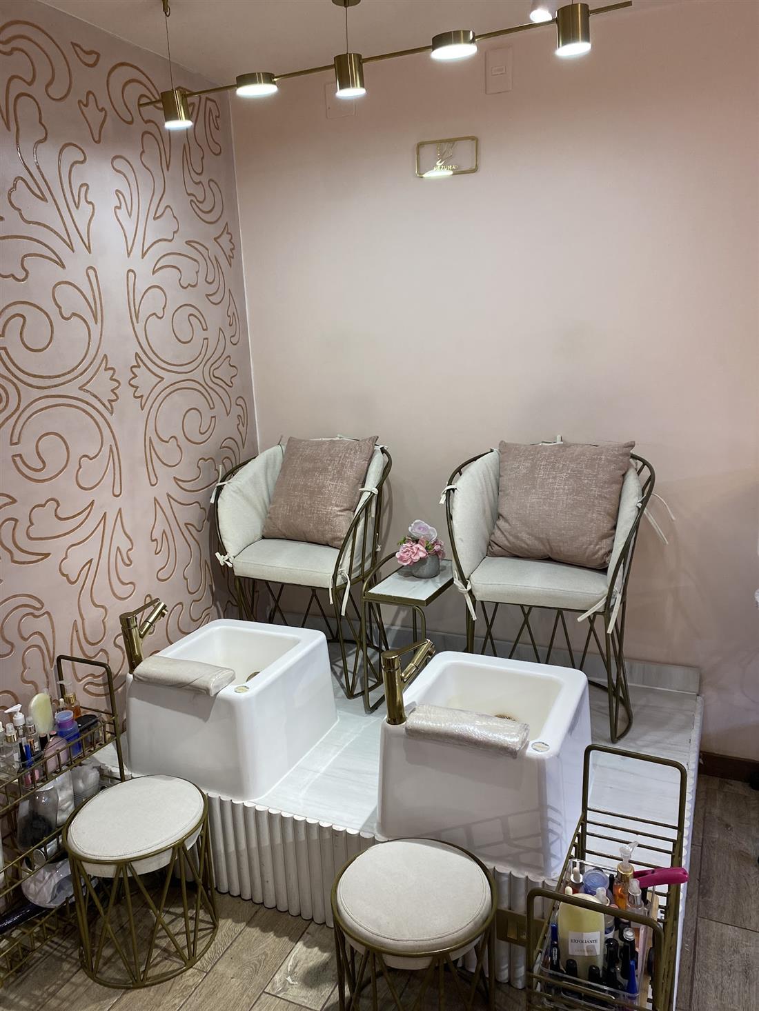 Sillones blancos de pedicura con pared de arabescos